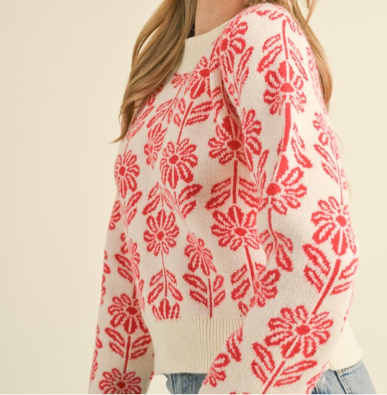 Woman wearing a floral pattern knit sweater on a beige background